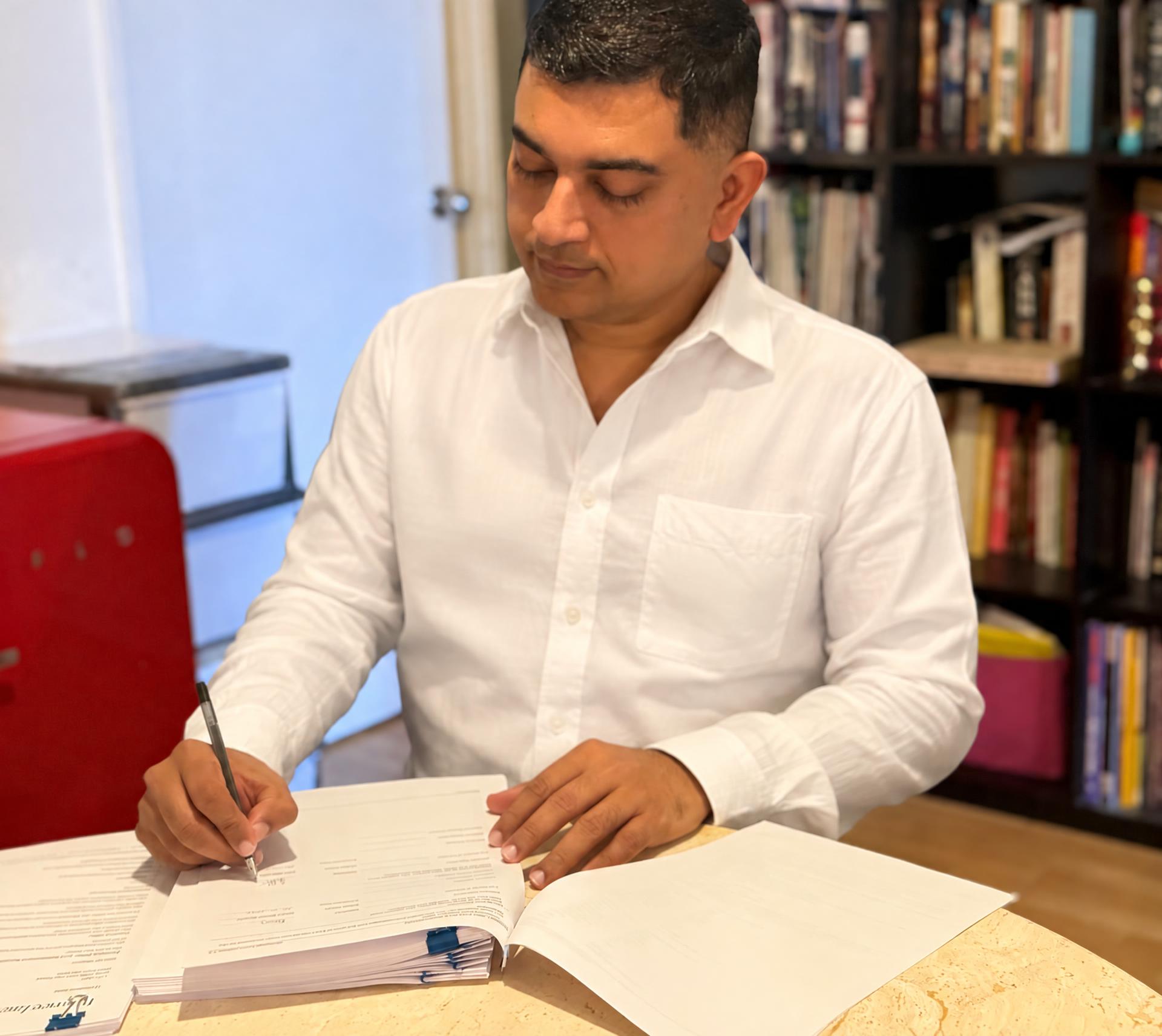 Eby Mathew, founder of ASH Foundation, reviewing documents at a table